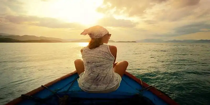 © soft_light - Fotolia | Woman traveling by boat at sunset among the islands.